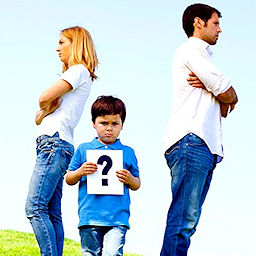 parents with child holding sign with question mark on it